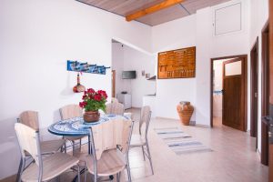 Photo of the dining area of the two-bedroom apartment, the door to the bathroom and the TV in the end
