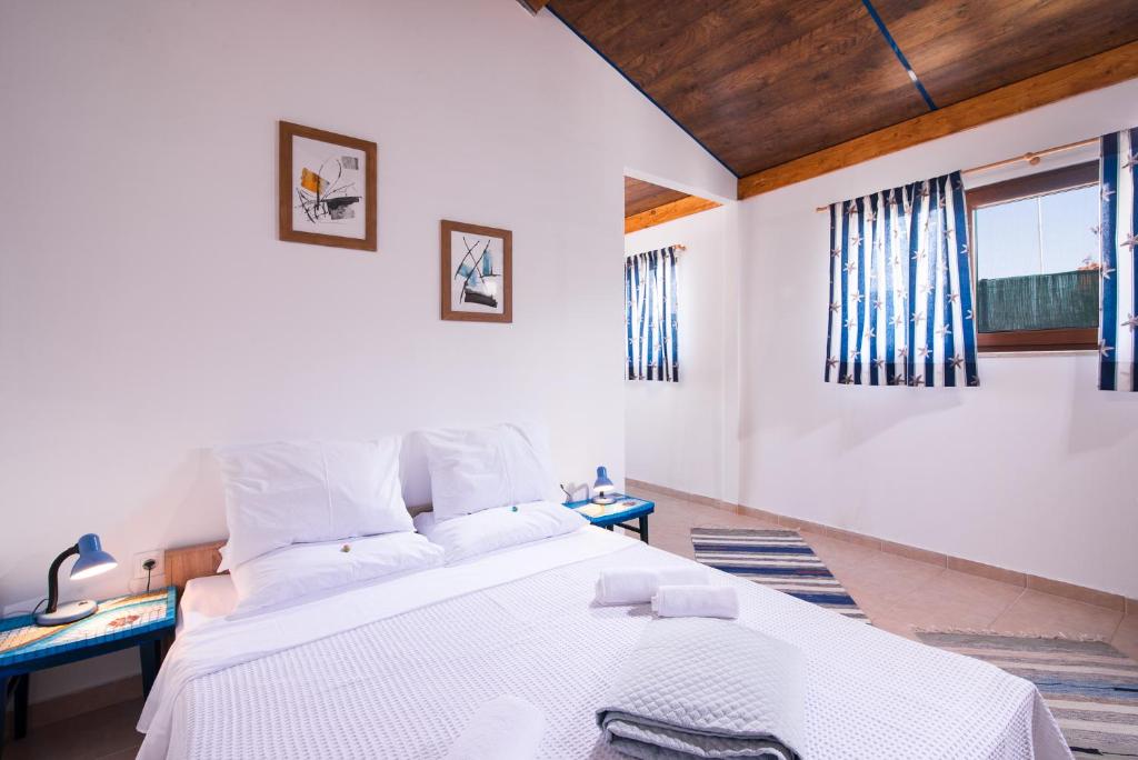 Photo of the larege bed with bedside tables, windows and pictures on the wall