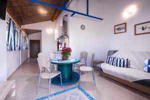 Photo of interior of small apartment with coach, dining table and kitchenette