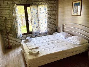 A photo of the second room with a single large bed and the window