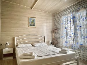 A photo of the first bedroom with a single large bed next to a window